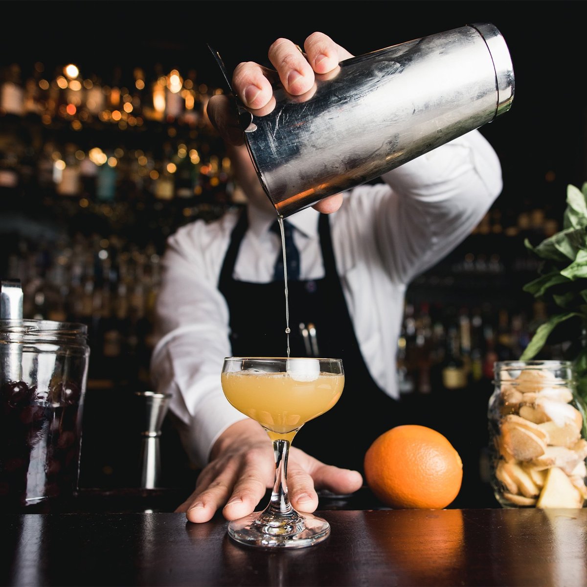 Ein Mann mixt einen Cocktail an einer Bar.
